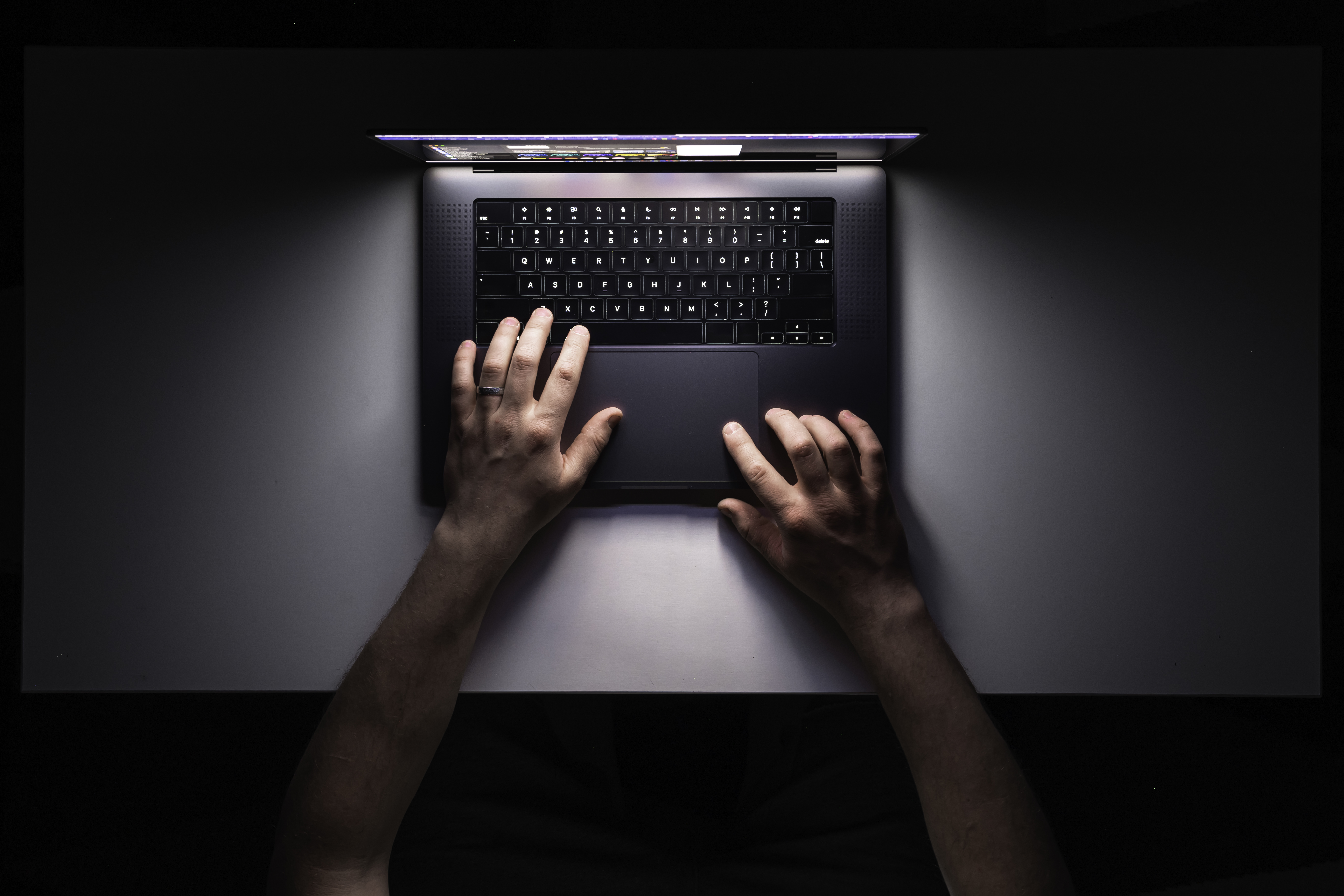 homem-usando-laptop-no-local-de-trabalho-a-noite-vista-de-cima